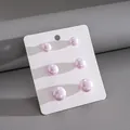 Vista dettagliata del set di sei orecchini a perla rosa in varie dimensioni, 6 pezzi - Set di 6 Orecchini a Bottone (HE34122) / Viola Chiaro