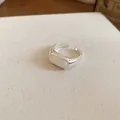Close-up detail of a minimalist silver open ring featuring an elegant white resin oval inlay - Open Ring / Silver-White