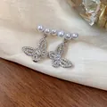 Detail of hollow butterfly stud earrings with sparkling crystals and elegant white pearls - Hollow Butterfly Style (HE26202) / Silver