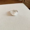 Elegant close-up of adjustable silver-plated ring with a smooth oval white resin stone center. - Open Ring / Silver