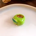 Primer plano de un anillo de manzana en esmalte verde brillante con detalle dorado. - Verde