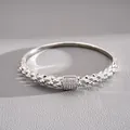 Dettaglio ravvicinato di un bracciale rigido in argento con pavé di cristalli al centro - Bangle con Texture Geometrica Micro-Pavé / Argento