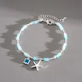 Dettaglio di un braccialetto di perline blu con ciondoli a stella marina e cristallo blu - Bracciale con Ciondolo Stella Marina e Strass Quadrato / Argento Blu