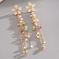 Close-up of elegant floral tassel earrings featuring colorful beads and pearls. - White