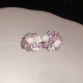 Dettaglio di orecchini a grappolo di fiori e perle in resina con strass luccicanti - Stile a grappolo di fiori / Viola e Bianco
