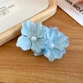 Close-up detail of a blue fabric flower hair clip with a central pearl accent decoration - Duckbill Hair Clips / Blue