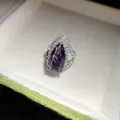 Detail view of a luxury teardrop purple zircon ring with silver-tone band - Purple