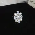 Detail of a 14k gold plated pearl ring with sparkling zircon floral design. - Silver