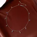 Detailed view of a silver-toned necklace featuring multiple colorful glass star charms. - Star Tassel Necklace / Silver (Multicolor Pendant)
