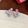 Macro view of elegant flower stud earrings with sparkling zircons and delicate white pearls - Silver-White