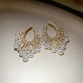 Close-up detail of vintage gold-tone earrings with pearls and shimmering zircons. - French Luxury Palace Style / Gold