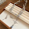 Detailed view of elegant silver-grey pearl necklace featuring crystal flower pendants - Gray