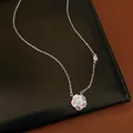 Detailed view of a rotating flower pendant necklace with shimmering zircon stones. - Silver-Blue Zirconia