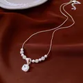Detailed view of vintage square zircon pendant and pearl necklace on red fabric. - Square Zirconia Pearl Necklace (HN12532) / Silver White