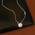 Detailed view of a rotating flower pendant necklace with pink zircon center. - Silver-Pink Zirconia