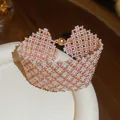 Dettaglio di un bracciale fatto a mano in perle oro rosa e bianche con chiusura magnetica. - Bracciale / Oro-Bianco