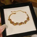 Close-up of French vintage gold bracelet with multicolored zircon stones in display box - Yellow
