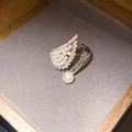 Close-up of angel wing open ring with marquise zircons and elegant white pearls - Star Wing Style