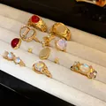 Detail of 9-piece gold ring set featuring varied resin stones and celestial motifs - 9-Piece Set / Gold