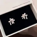 Elegant white bow knot stud earrings with sparkling zircon center in a jewelry box. - Silver-Pink