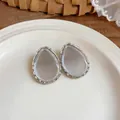 Macro detail of teardrop resin stud earrings with textured silver-tone metal frame - Silver Frame / 925 Silver Needle / White