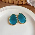 Close-up detail of elegant teal teardrop resin earrings with gold wavy textured edge - Gold Frame / 925 Silver Needle / Blue