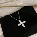 Detailed view of silver-tone cross star pendant with zircon stones and quilted pattern - Silver