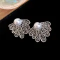 Close-up of vintage hollow leaf earrings with pearls and silver needles in court style - Silver