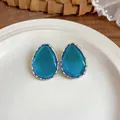Close-up of teardrop resin earrings with silver wavy edge on a white ceramic plate - Silver Frame / 925 Silver Needle / Blue