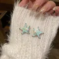 Close-up of mint green starfish stud earrings with pearl on white fuzzy sleeve - Star Pearl Style (HE32105) / 925 Silver Needle / Mint Green