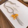 Close-up of a stylish orange resin horse pendant necklace featuring silver chain tassels - Necklace / Silver-Coffee