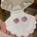 Dettaglio ravvicinato di orecchini a lobo tondi in zircone rosa in un portagioie a conchiglia. - Orecchino Halo Rotondo / Oro rosa - Viola