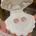 Primo piano di eleganti orecchini a lobo in zircone pesca in scatola a conchiglia. - Orecchino Halo Rotondo / Oro Rosa-Bianco