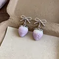 Close-up of delicate lilac strawberry earrings with silver-toned beaded bow design. - Bowknot Strawberry Style (HE32060)