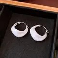 Macro detail of minimalist silver brushed texture hoop earrings with 18K gold plating finish - Silver