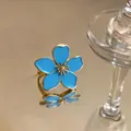 Close-up of an elegant blue enamel flower ring with an adjustable golden metal band - Flower Open Ring / Gold-Blue