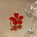 Detailed view of an elegant gold metal ring featuring a vibrant red enamel flower design. - Flower Open Ring / Gold-Red