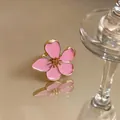 Close-up macro shot of a delicate pink enamel flower ring with golden metal edges - Flower Open Ring / Gold-Pink