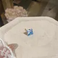 Dettaglio ravvicinato dell'orecchino a lobo con zircone blu sfaccettato e perno dorato - Pezzo Singolo / Blu