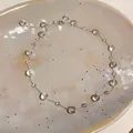 Dettaglio di una collana minimalista con perle di vetro trasparenti irregolari - Collana choker / Argento