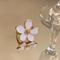 Detail view of an elegant gold flower ring with white enamel petals on a mirror - Flower Open Ring / Gold-White