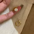 Detailed view of elegant gold hoop earrings with sparkling round cubic zirconia stones - Gold (18K Gold Plated)