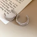 Detailed view of textured silver C-shaped hoop earrings with a vintage finish - Silver