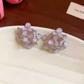 Close-up of sweet floral stud earrings featuring sparkly pink enamel and silver edges - Silver Style / Pinkish Grey