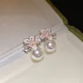 Dettaglio degli orecchini a fiore placcati in oro 18k con perle e smalto rosa delicato - Fiore Rosa / Argento