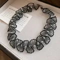 Close-up of elegant handmade grey pearl and black bead woven lace necklace in a jewelry tray - Necklace / Black