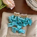 Detail of summer chiffon flower tassel earrings with sparkling zircon studs on cushion. - Silver Earring Post Style / Blue