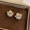 Close-up of vintage flower-shaped ear clips with sparkling marquise crystals - Clip-On Earrings / Gold