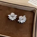 Close-up of elegant flower-shaped ear clips with sparkling marquise-cut stones. - Clip-On Earrings / Silver