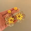 Close-up detail of yellow raffia flower earrings with golden hollow petals - Style 12 (Silver Pin-Gold) / Yellow